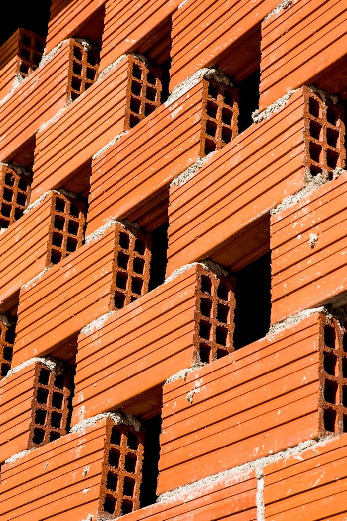 Close-up view of a red clay brick wall showing geometric pattern.